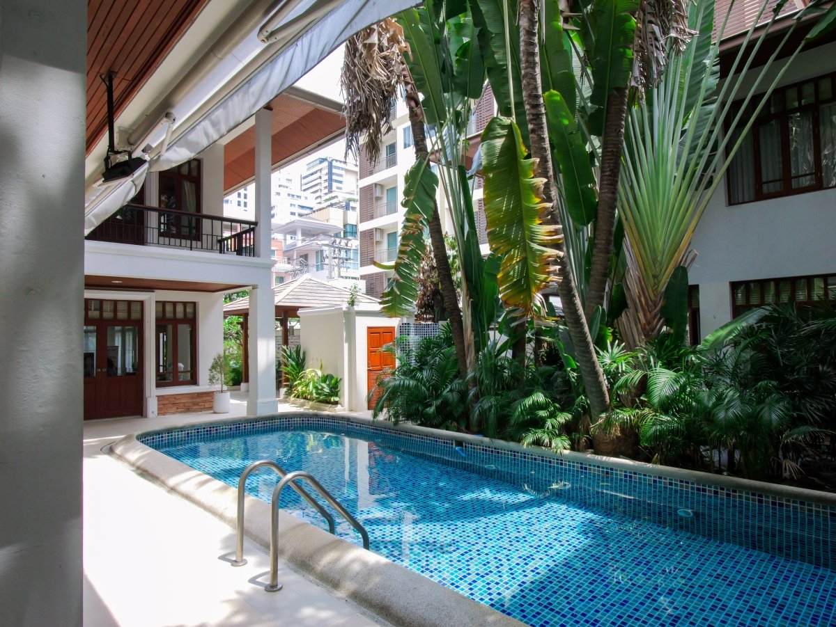 Tranquil outdoor pool and tropical garden at Healthi-Life Bangkok, offering a peaceful setting for post-treatment relaxation in the heart of Ekkamai.