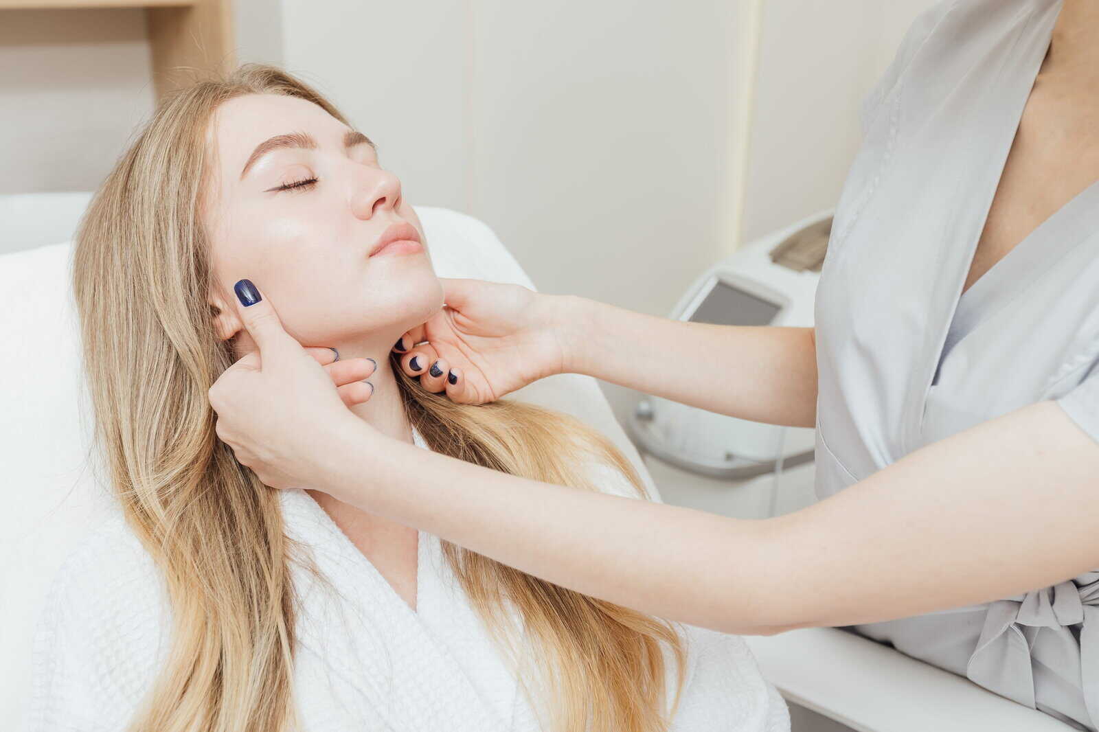 A medical staff member assesses a guest's face during a consultation for exosome therapy